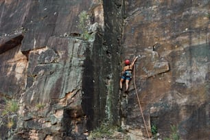 a man climbing up the side of a mountain