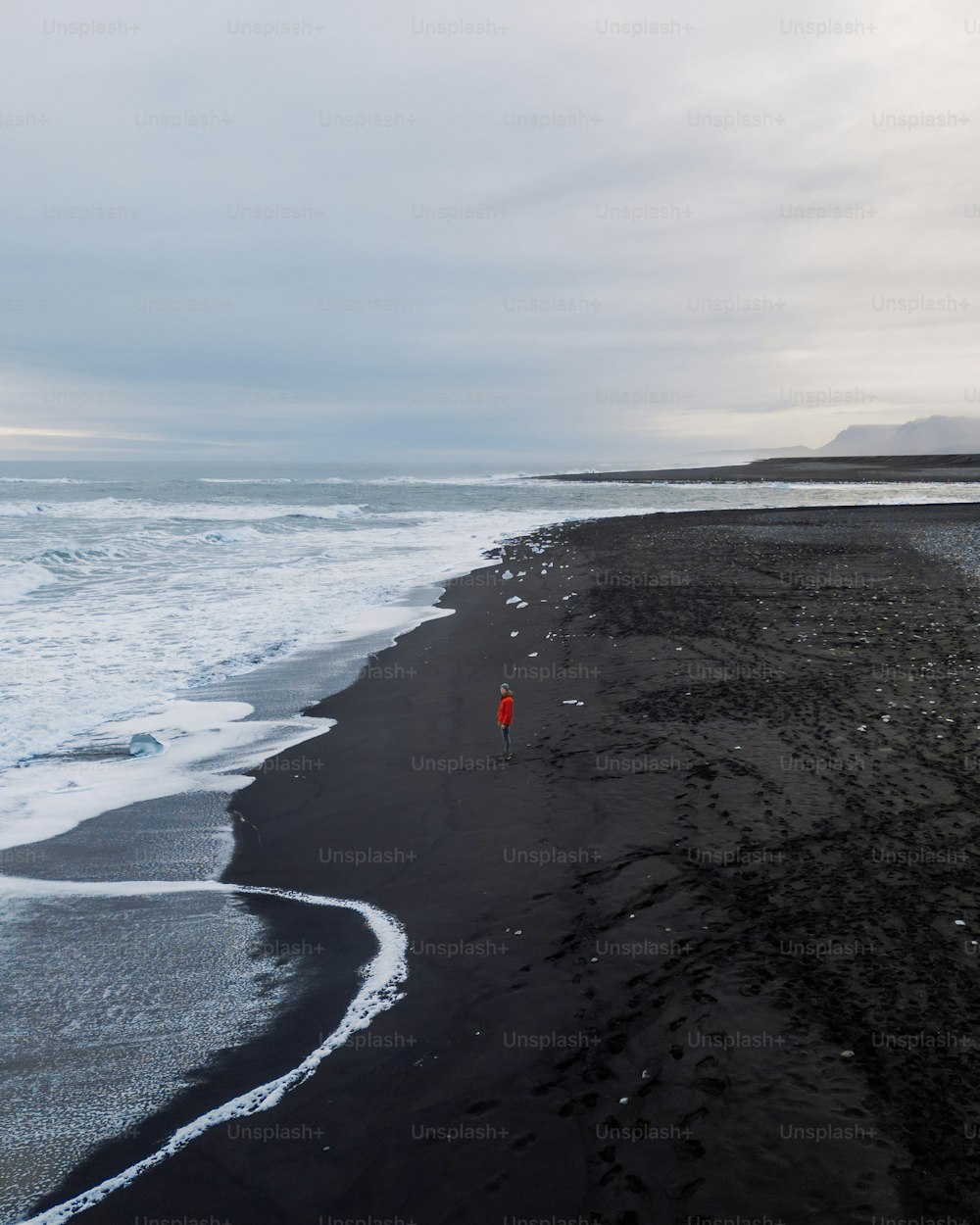 Una persona in piedi su una spiaggia vicino all'oceano