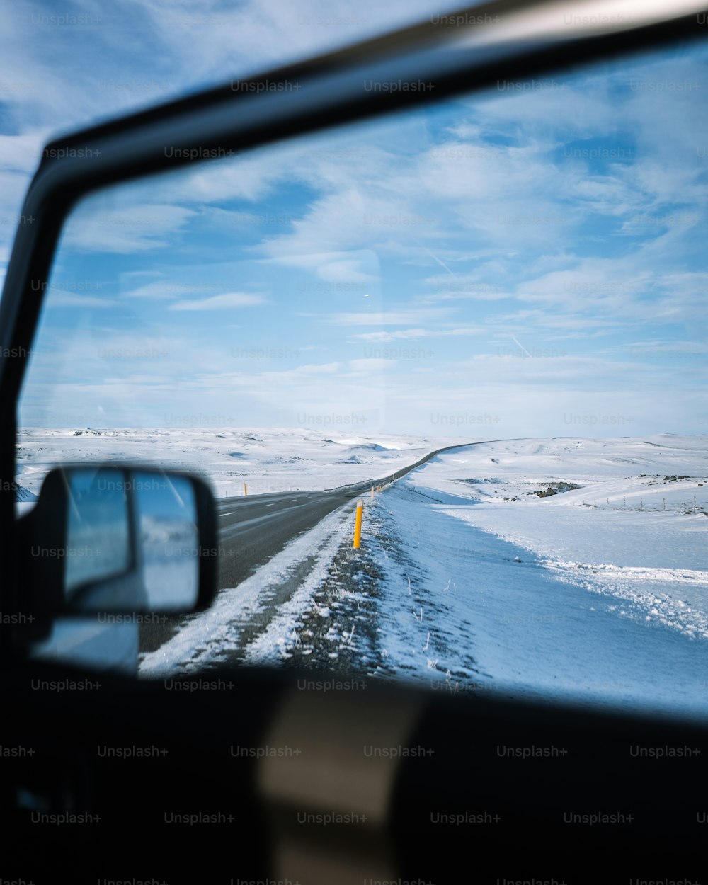 a view of a snowy road from inside a vehicle