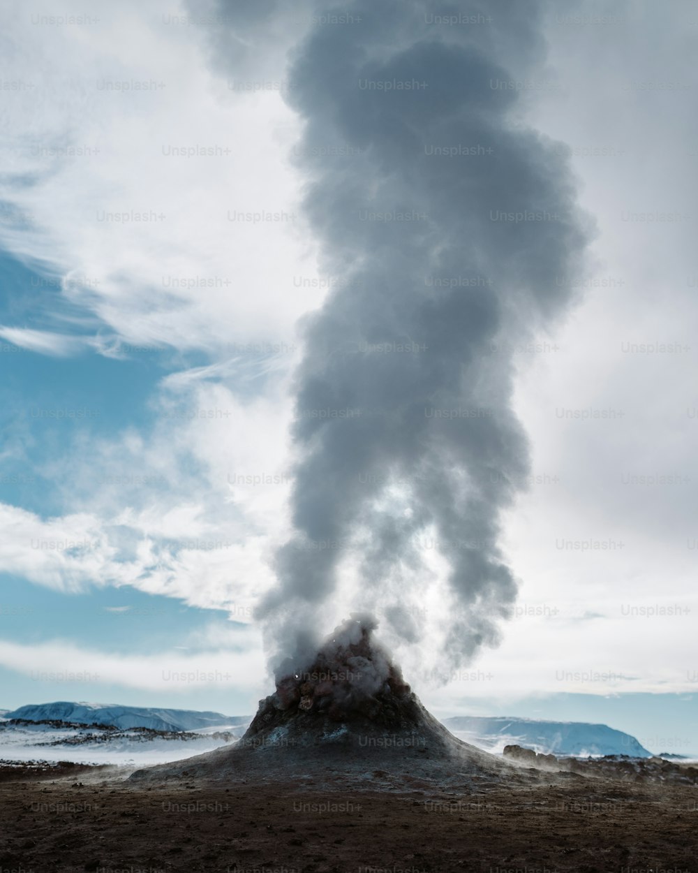 a large plume of smoke coming out of the top of a mountain