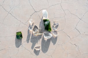 quelques bouteilles vertes posées sur une surface fissurée