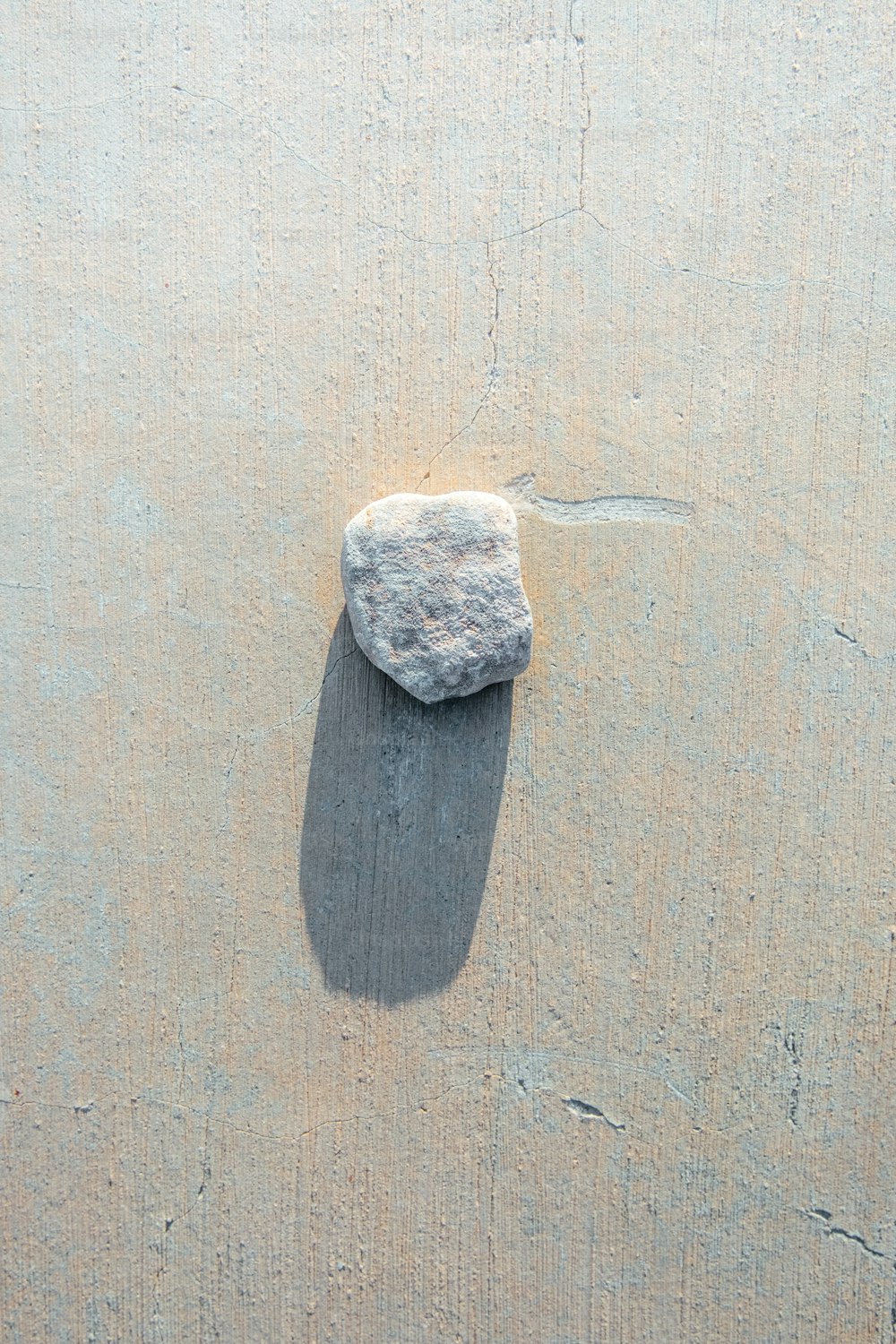 a rock sitting on top of a sandy beach