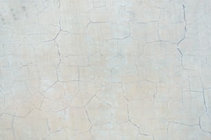 a close up of a white wall with cracks in it