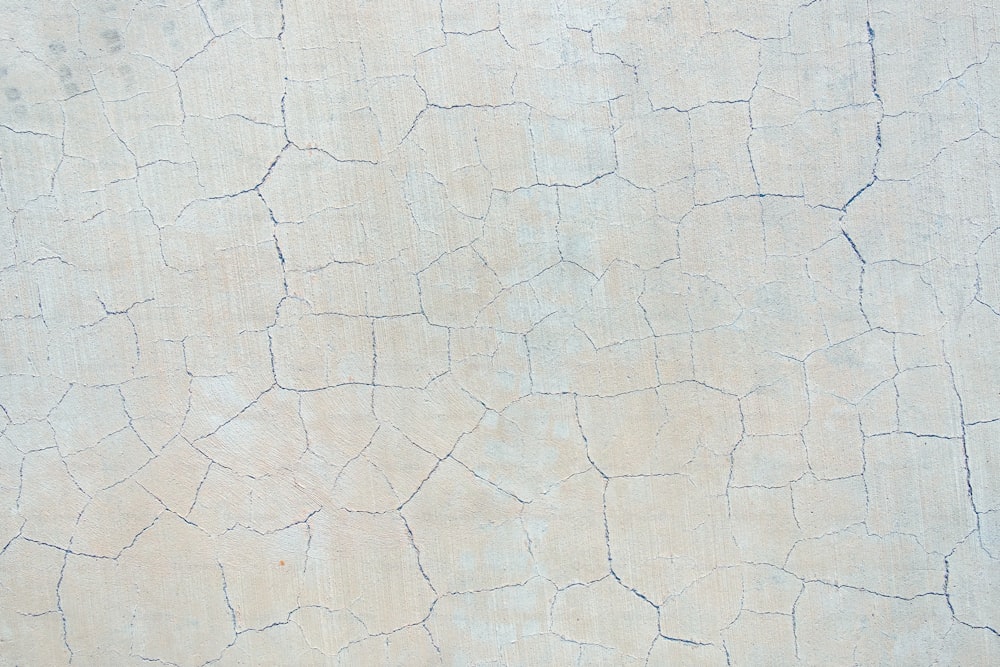 a close up of a white wall with cracks in it