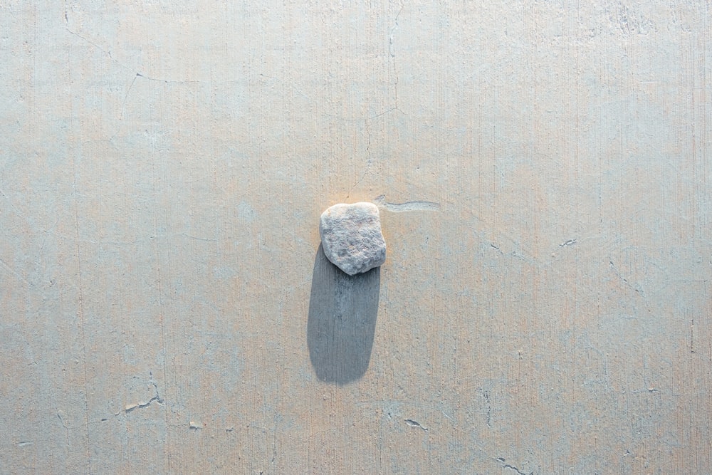 a rock sitting on top of a sandy beach