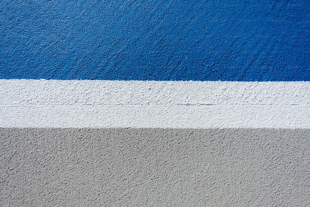 un mur bleu et gris avec une bande blanche
