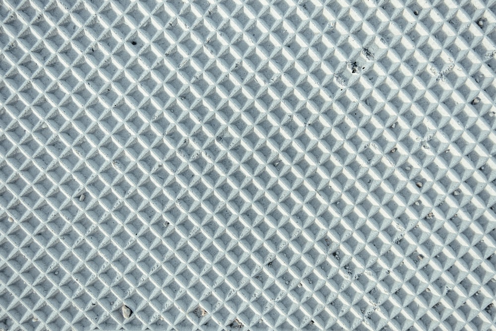 a close up of a metal surface with a diamond pattern