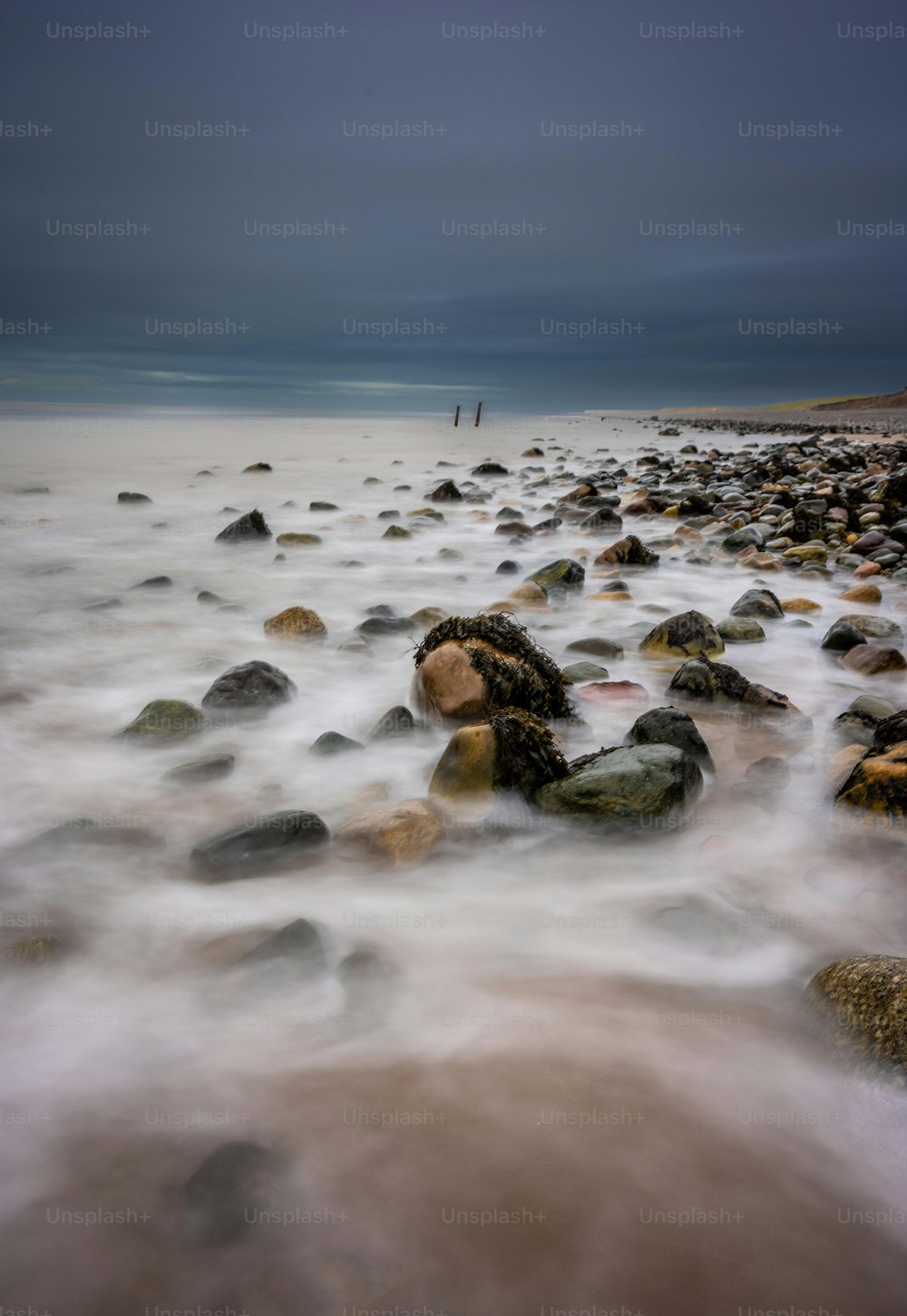 Une photo longue exposition d’une plage rocheuse