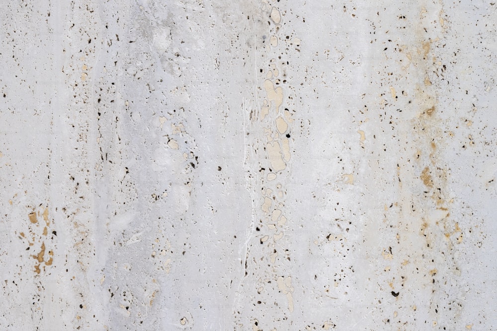 a close up of a white wall with brown spots