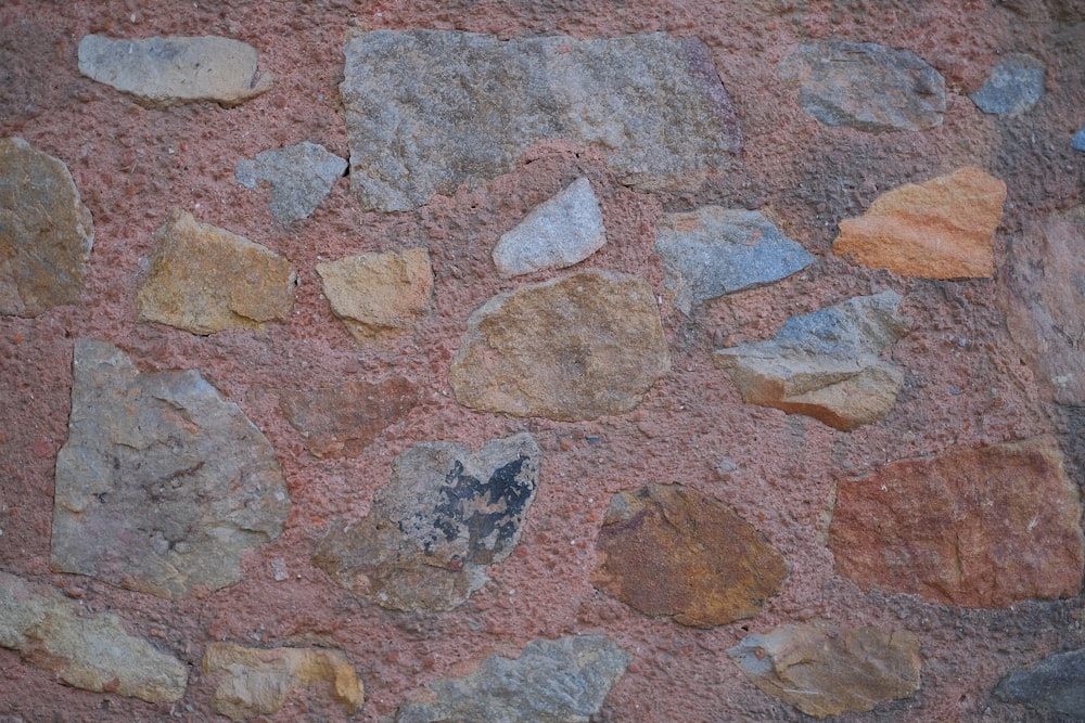 un primo piano di un muro di pietra con rocce su di esso