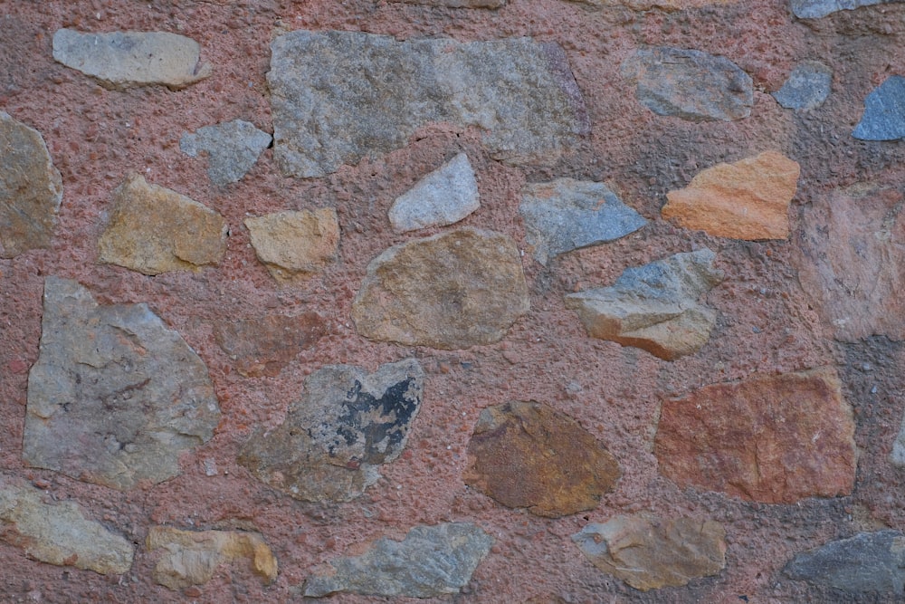 un primo piano di un muro di pietra con rocce su di esso