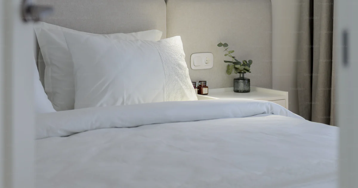 Un lit blanc avec des draps et des oreillers blancs photo – Image de ...