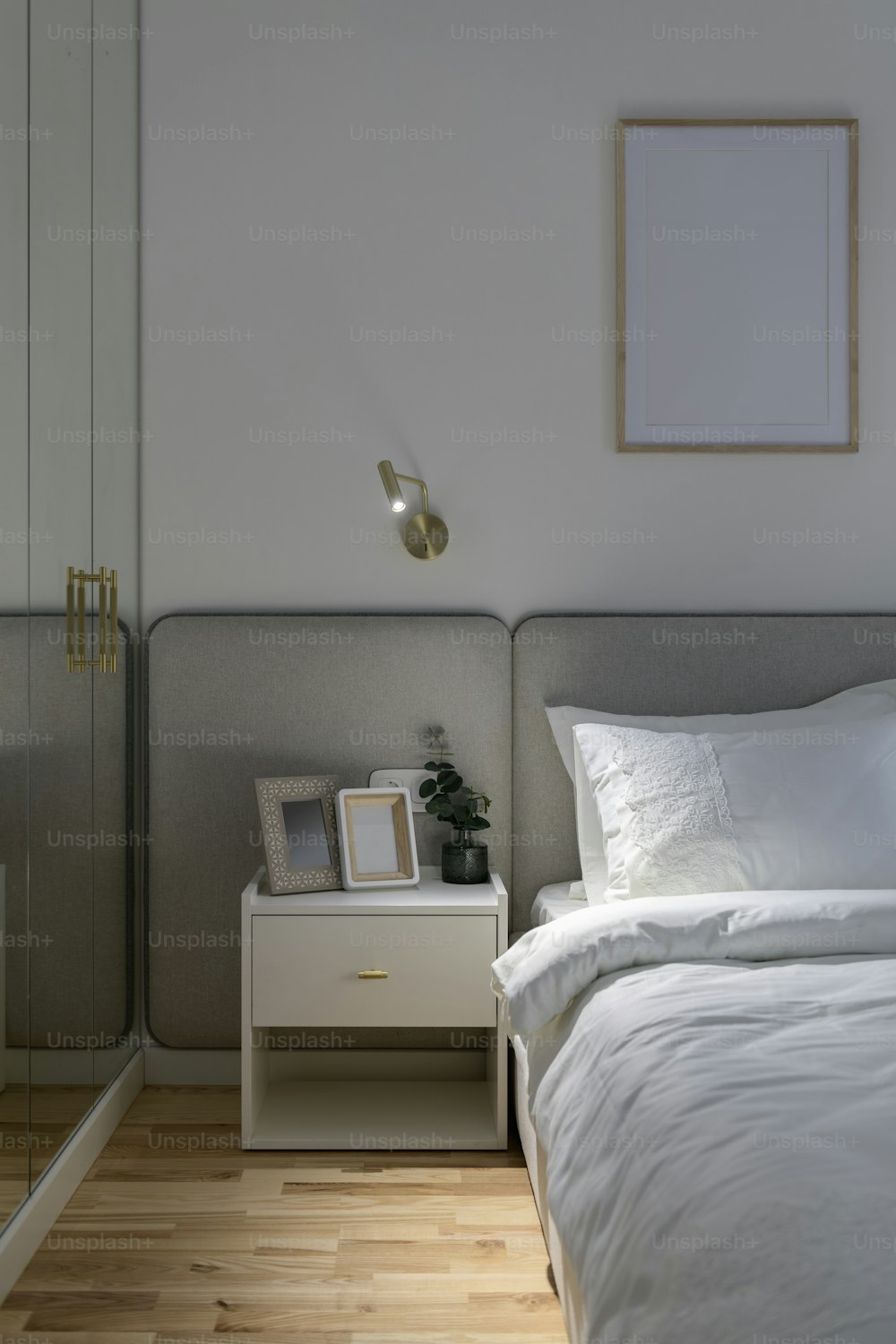 a bedroom with a bed, nightstand, and mirror