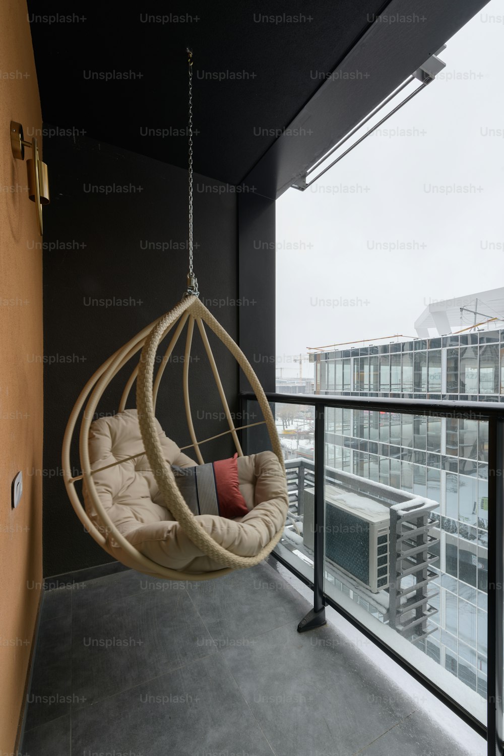 a hanging chair on a balcony overlooking a city