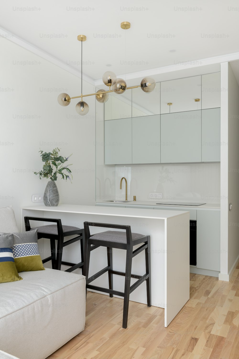 a kitchen with a white counter top next to a white couch