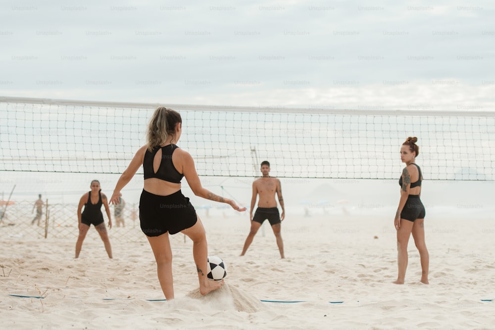 a group of people playing a game of volleyball on the beach