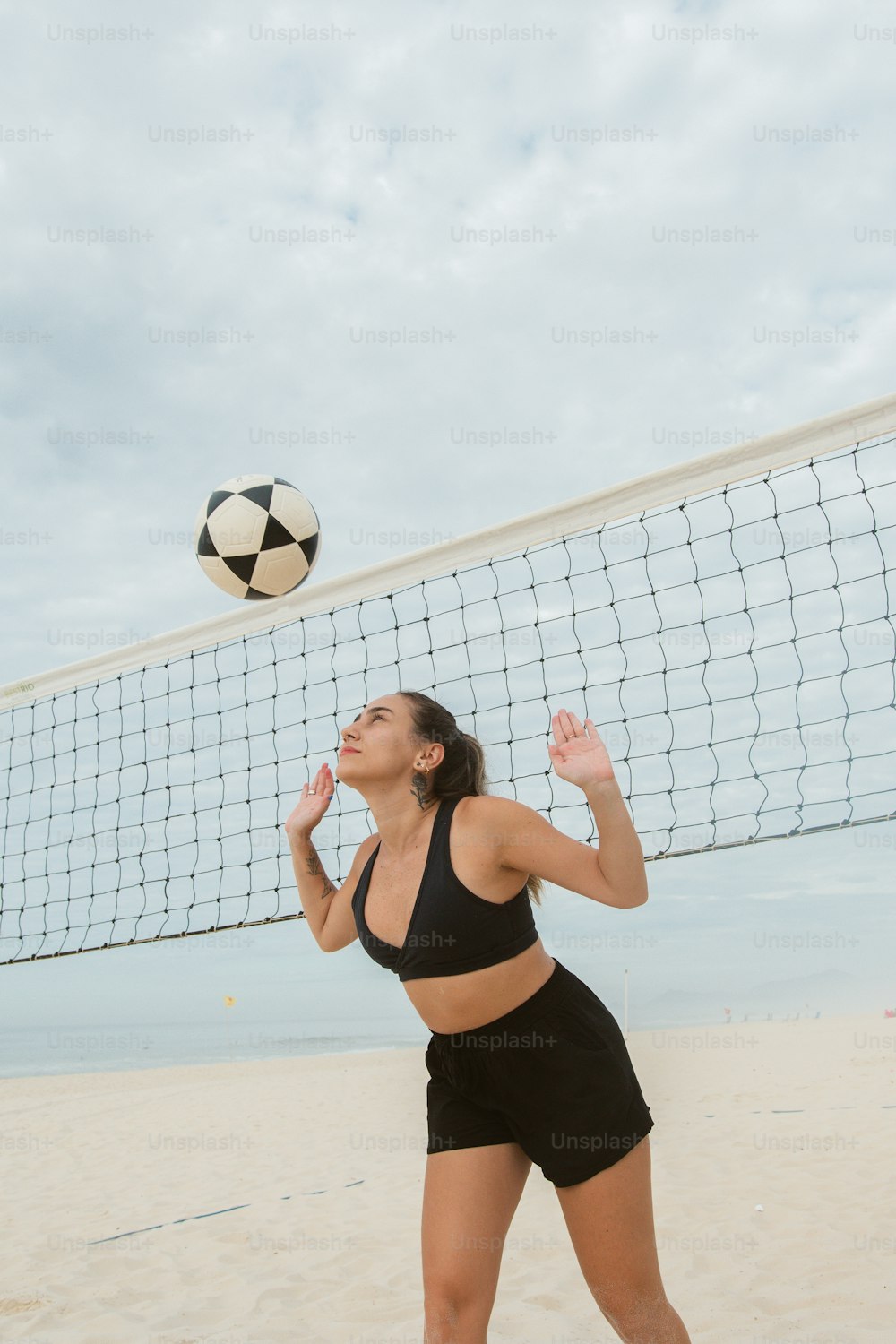 a woman is playing volleyball on the beach