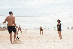 a group of people on a beach playing volleyball