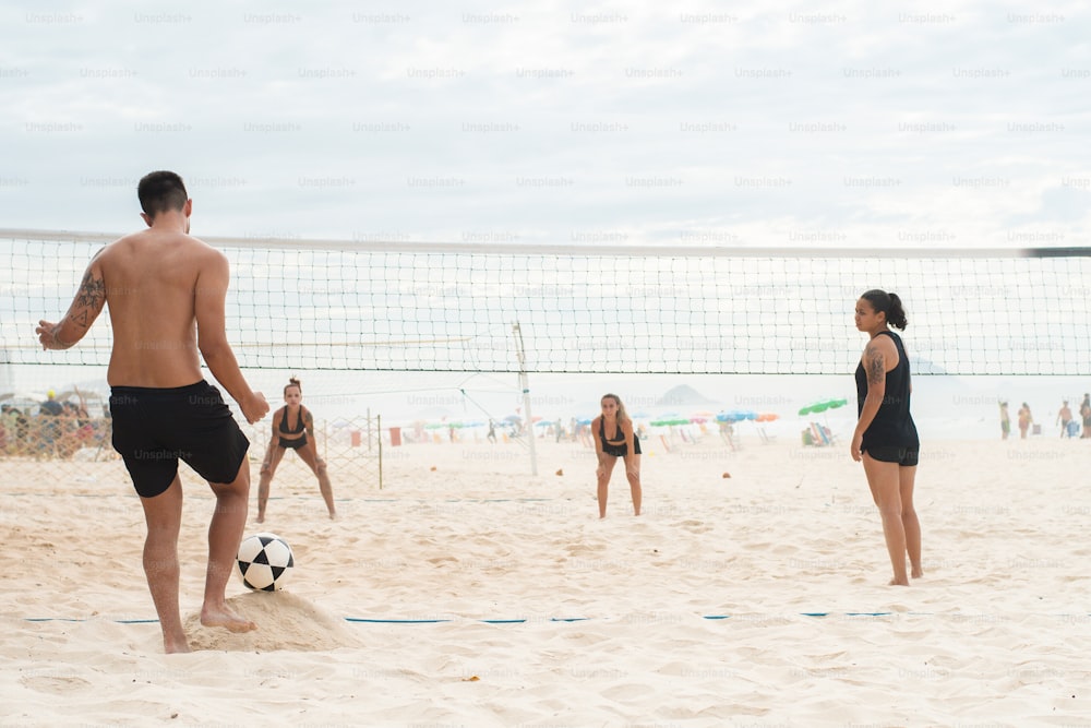 um grupo de pessoas em uma praia jogando voleibol