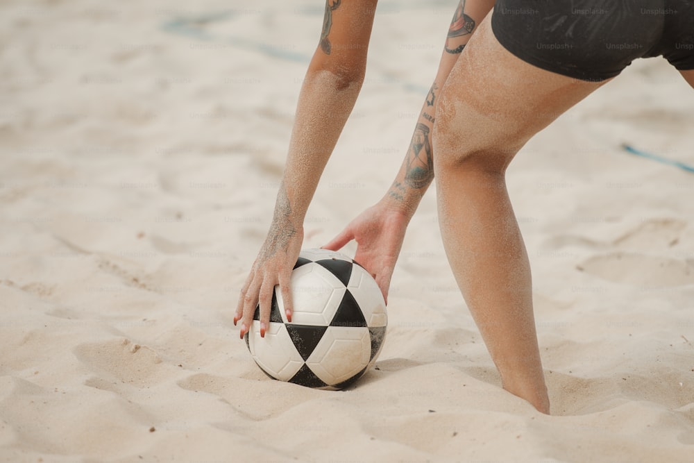 Un homme tatoué sur le bras tenant un ballon de football
