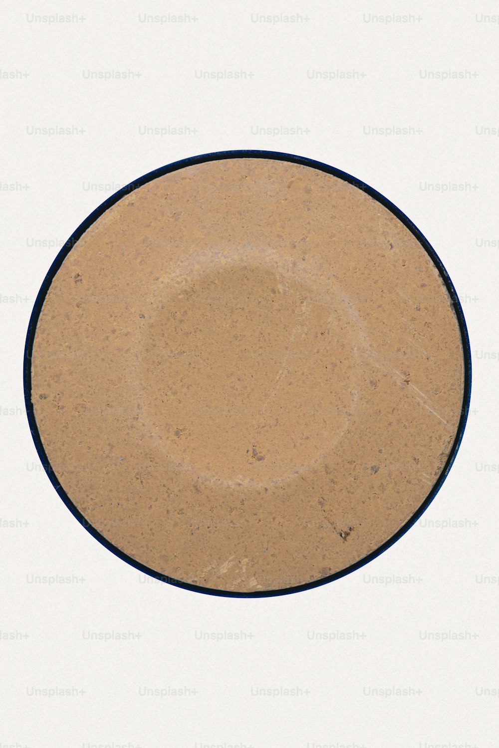 eine braune Platte mit blauem Rand auf weißem Hintergrund