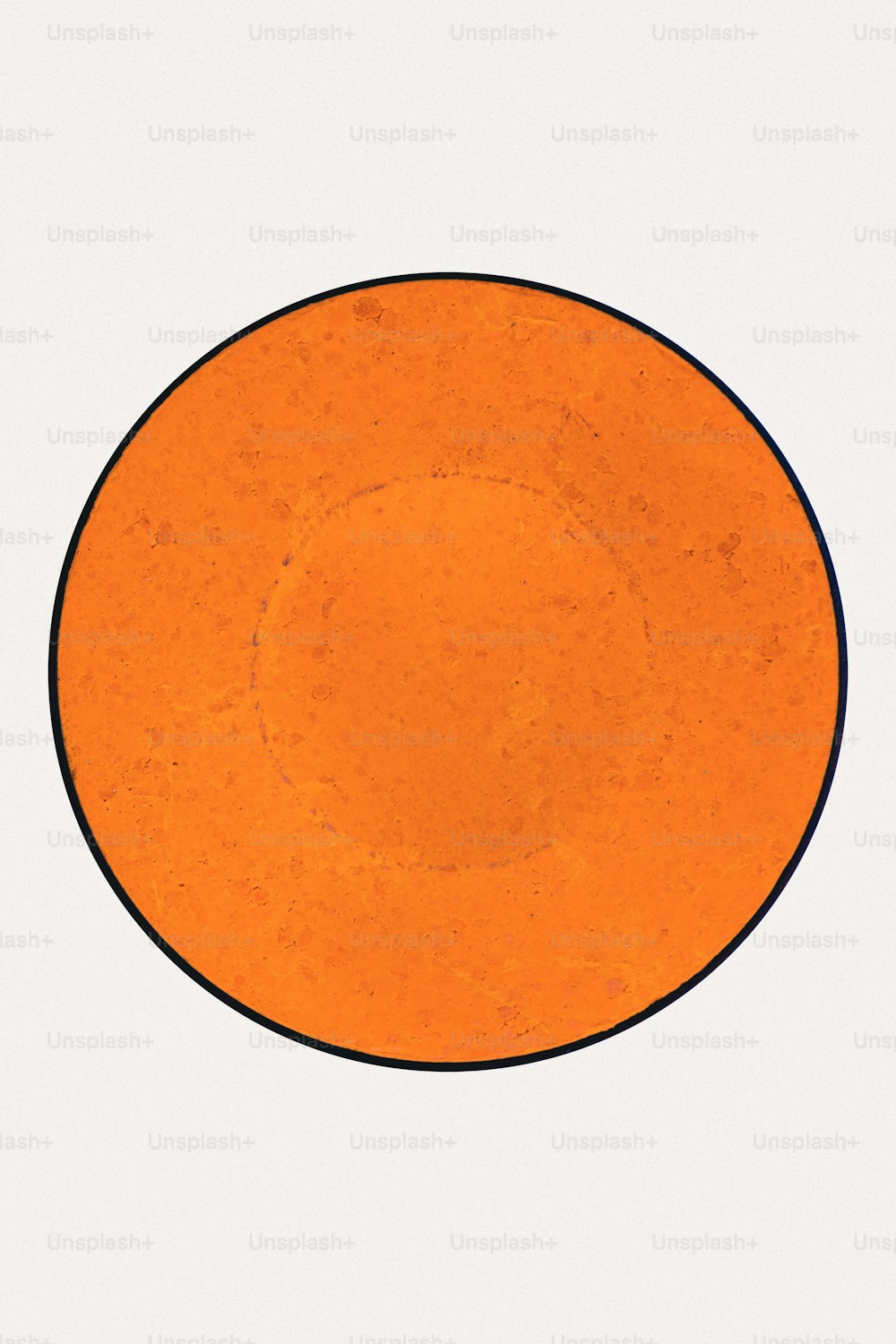 an orange plate with a black border on a white background