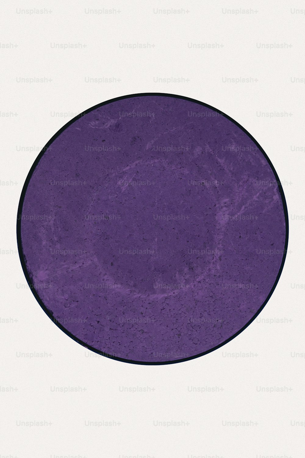 a purple plate with a black rim on a white background