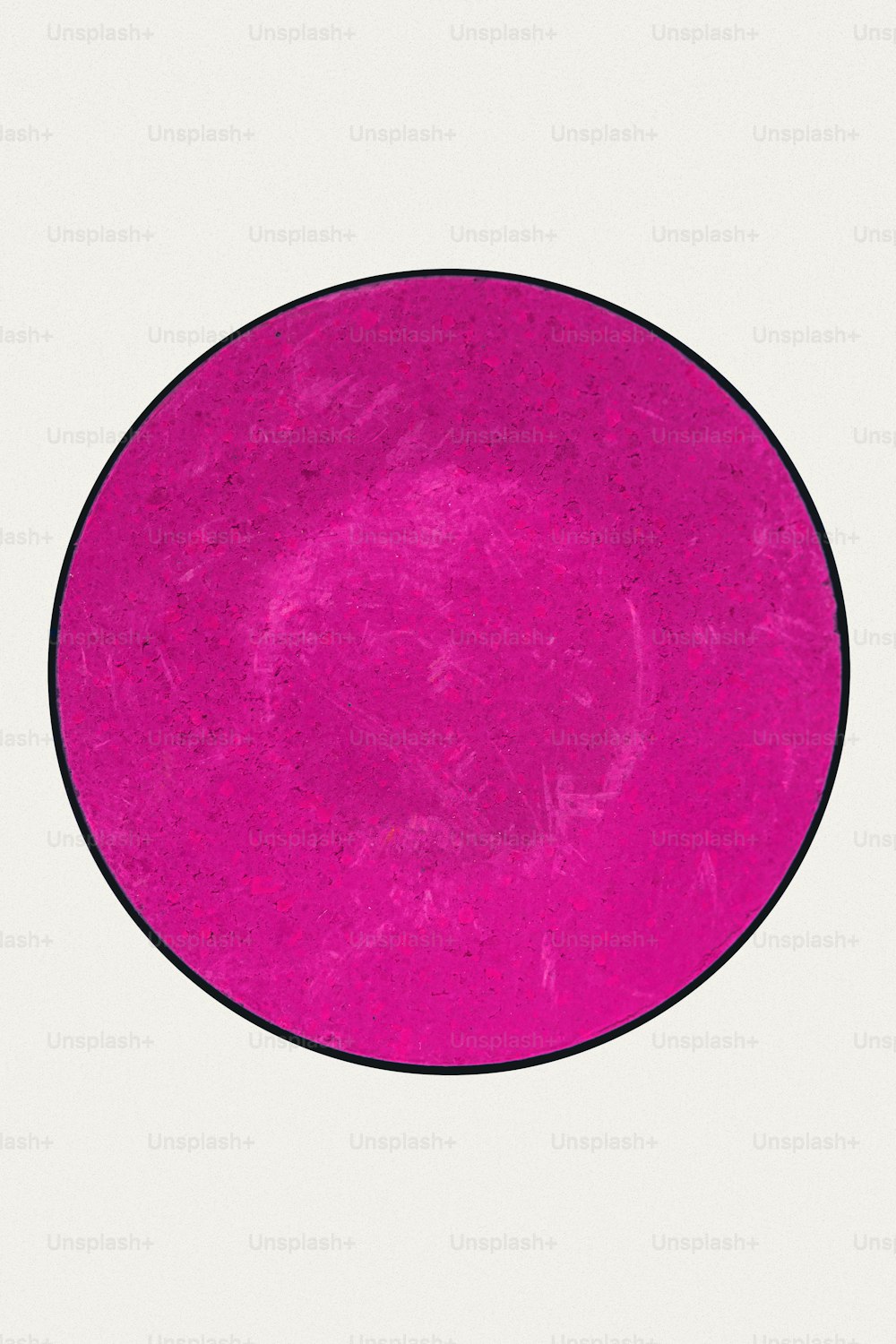 Un círculo rosa con un borde negro sobre un fondo blanco