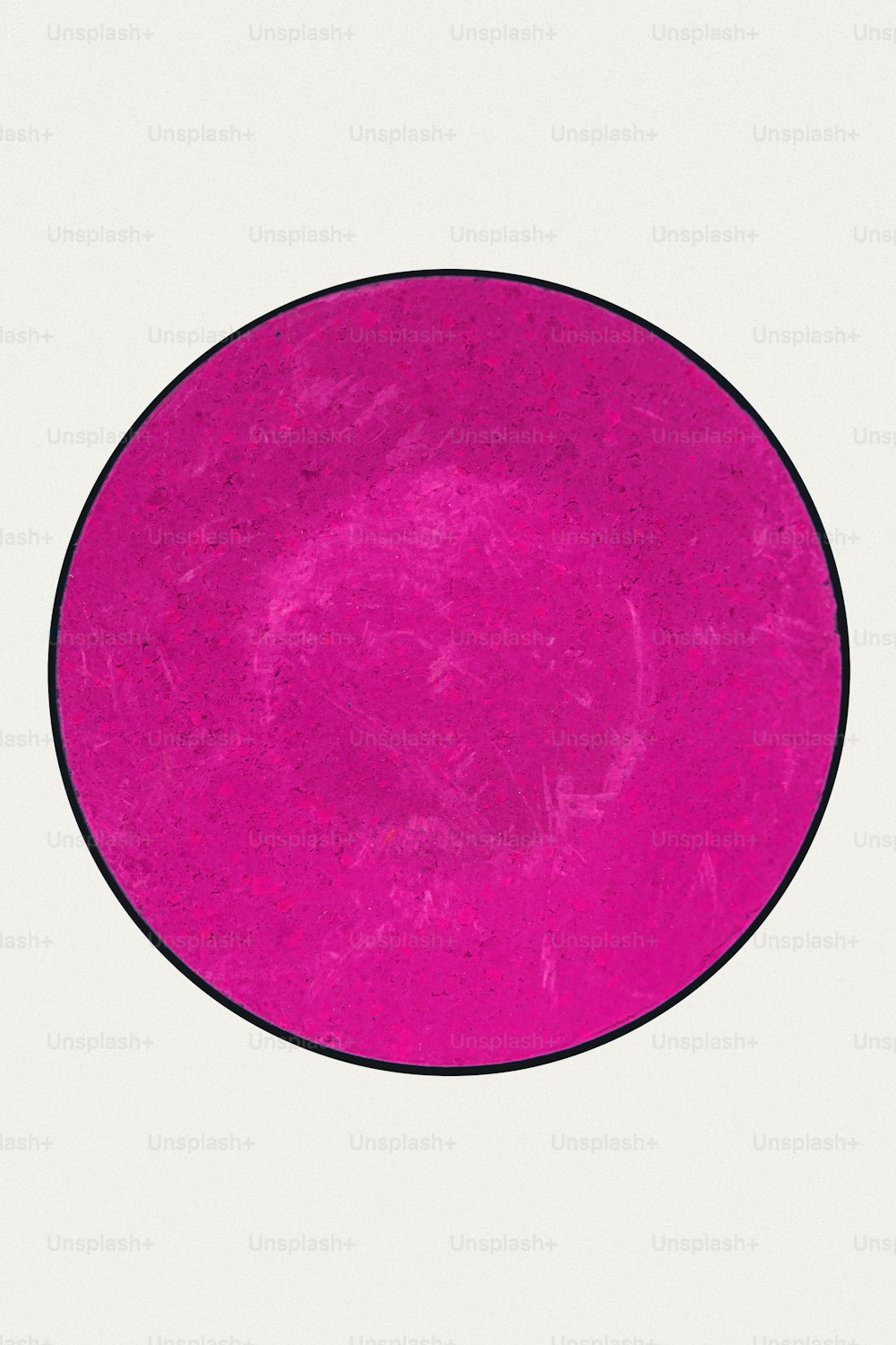 a pink circle with a black border on a white background