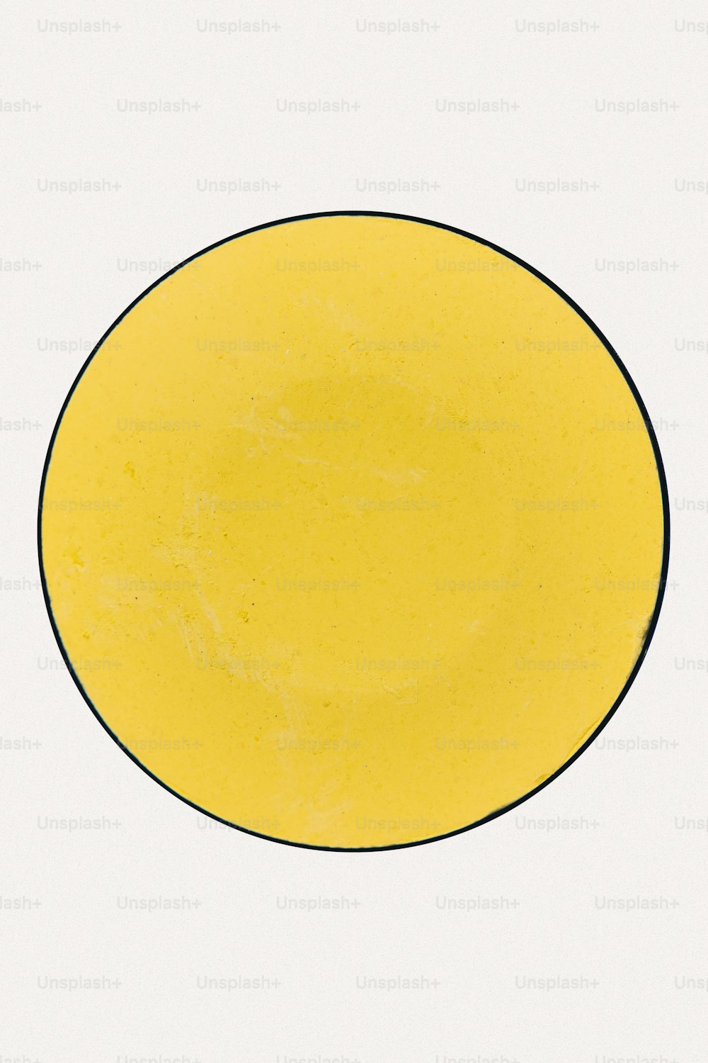eine gelbe Platte mit schwarzem Rand auf weißem Hintergrund