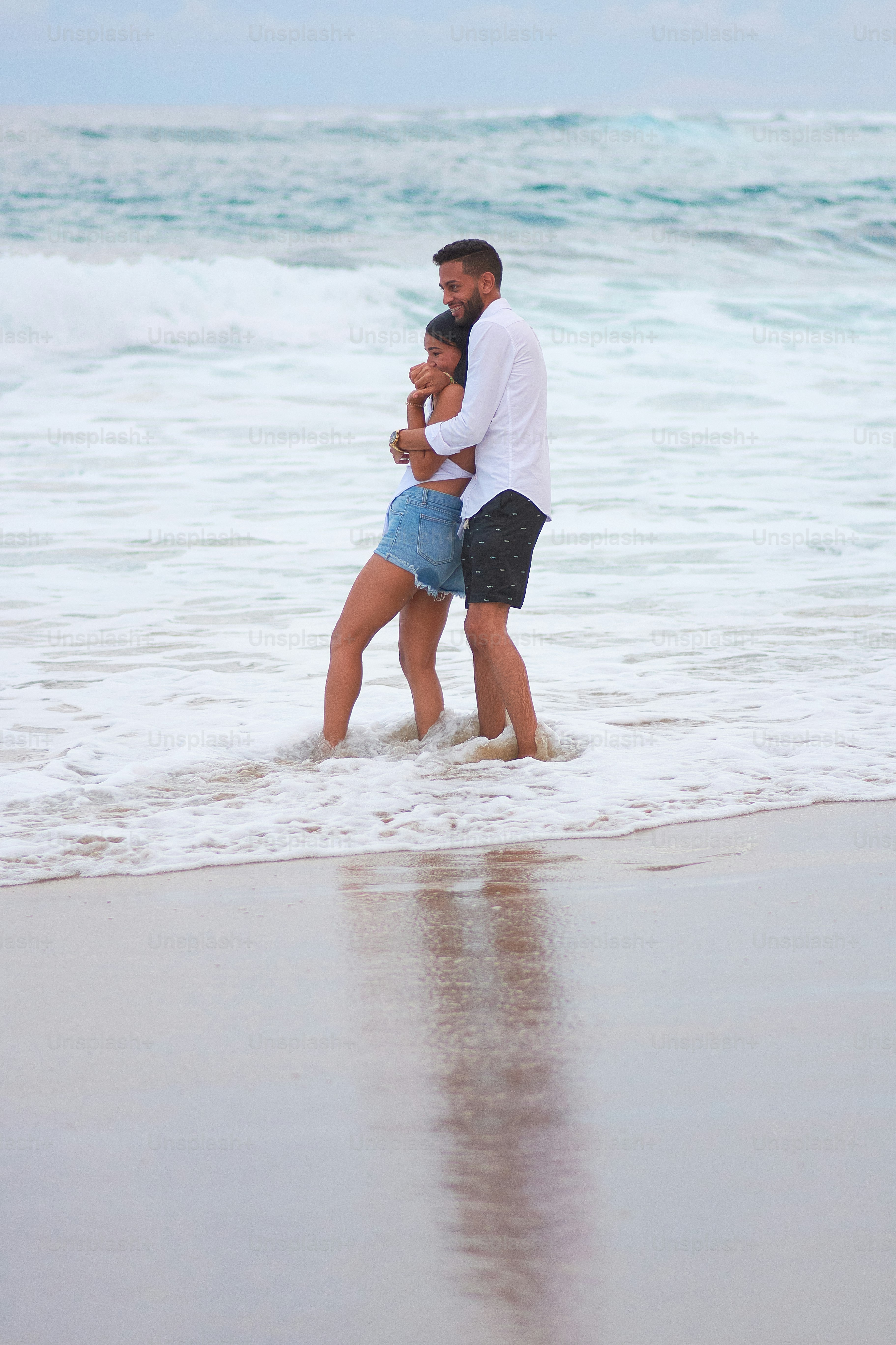 a man and a woman embracing on the beach