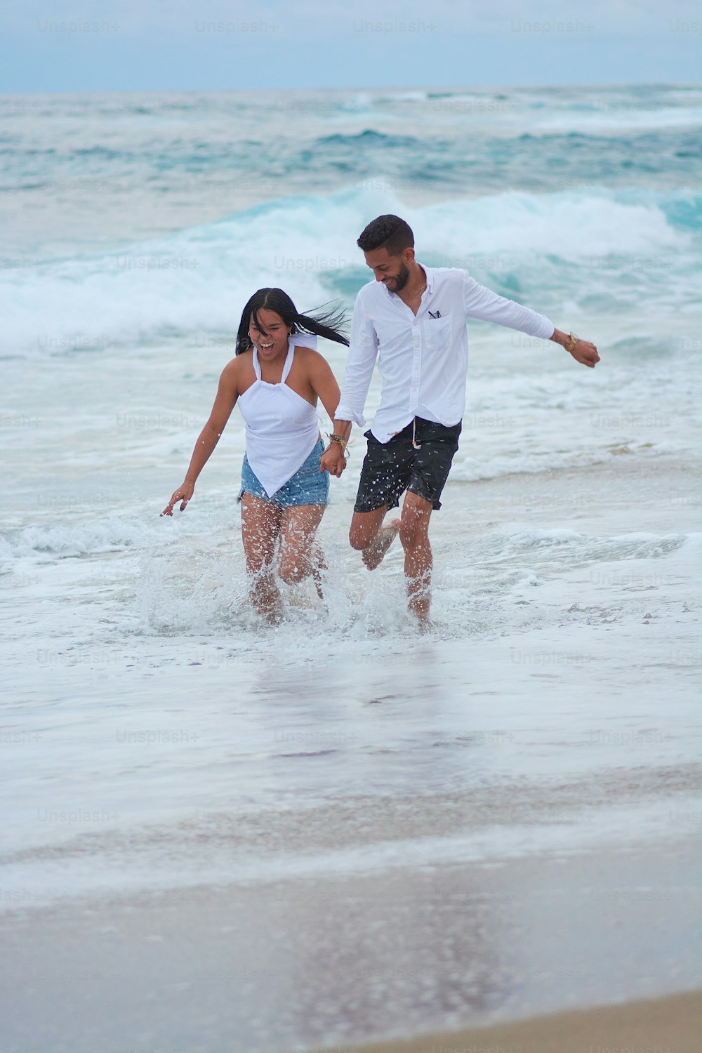 한 남자와 한 여자가 바다를 걷고 있다