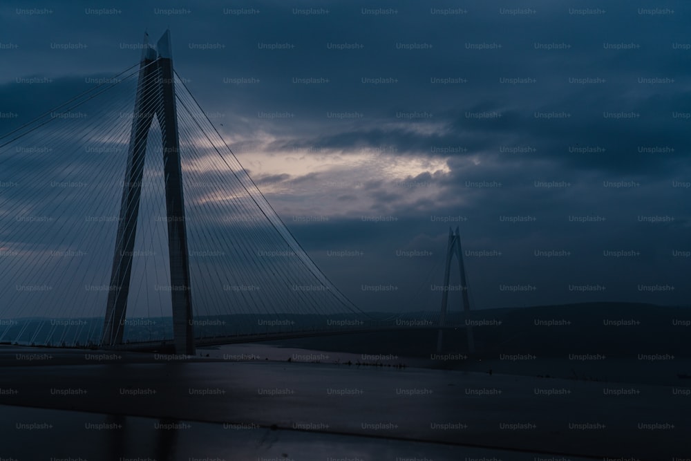 a very tall bridge with a cloudy sky in the background