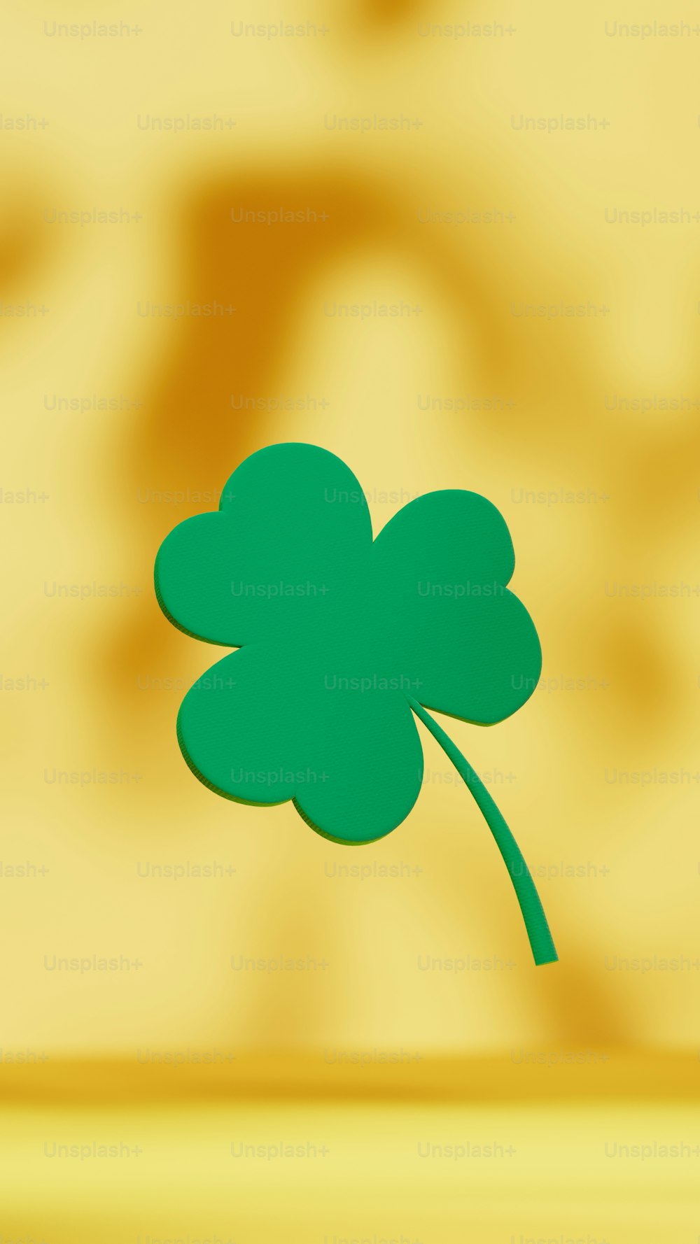 a green four leaf clover on a yellow background