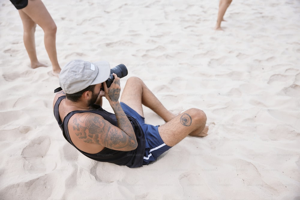砂の中に座って携帯電話で話している男性
