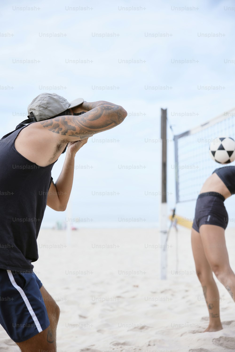 a man and a woman playing volleyball on the beach
