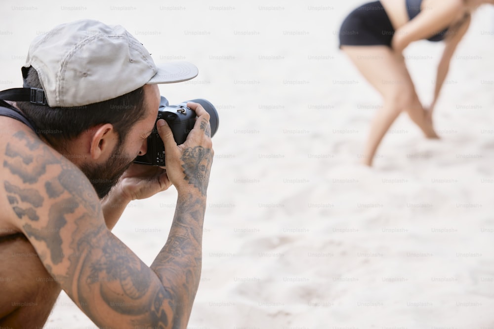 a man taking a picture of a woman on the beach