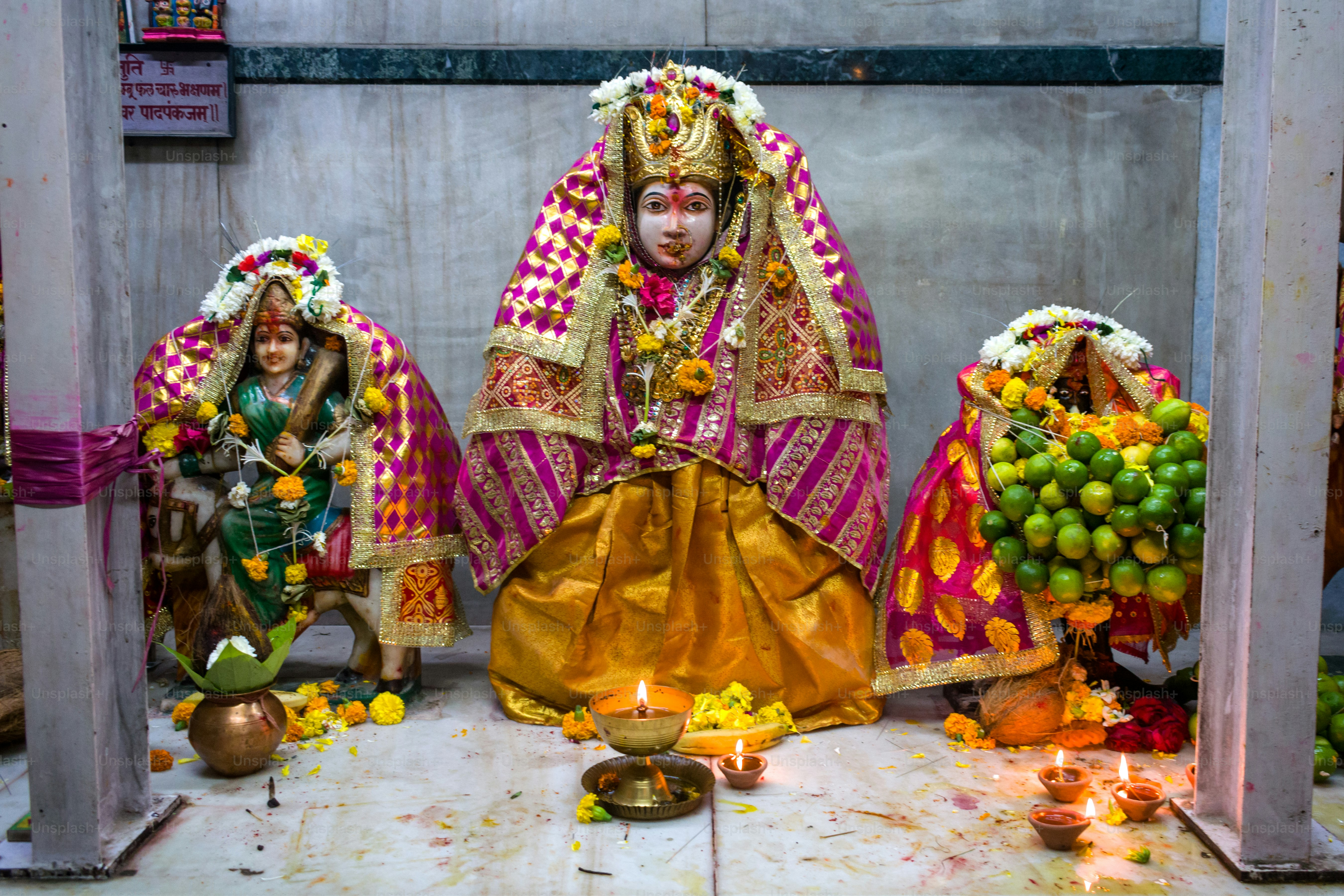 a statue of a woman in a colorful outfit surrounded by fruit