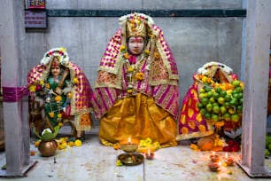 a statue of a woman in a colorful outfit surrounded by fruit