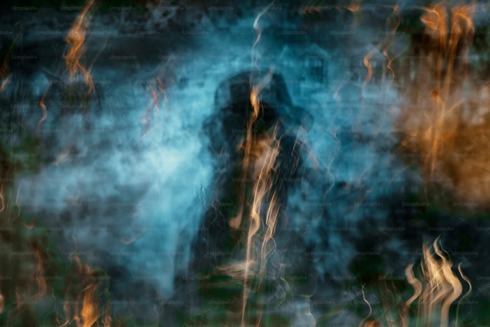 uma imagem borrada de uma pessoa em pé na frente de um incêndio