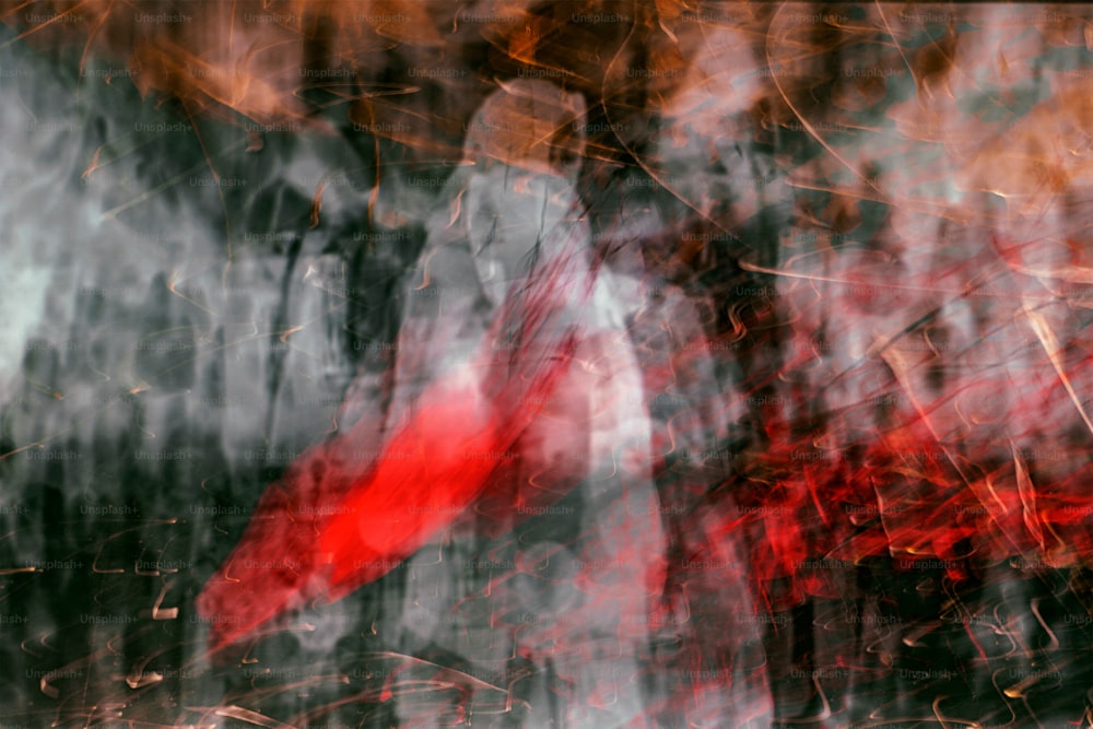 un'immagine sfocata di una persona che tiene un ombrello rosso