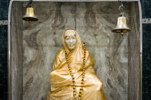 uma estátua de uma pessoa vestindo um manto amarelo