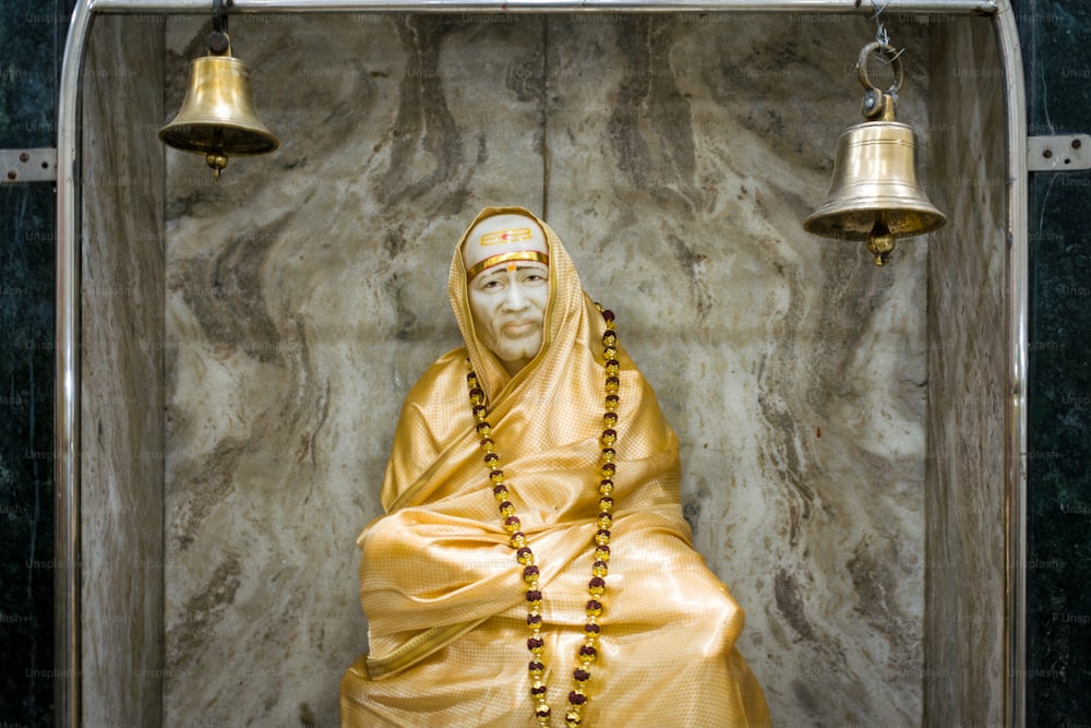 une statue d’une personne portant une robe jaune