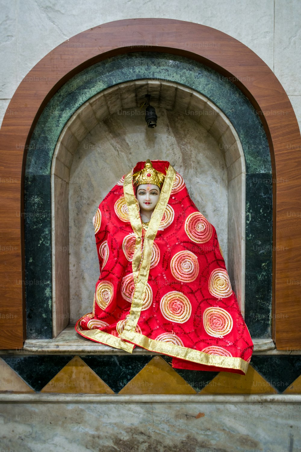 una statua di una donna vestita con un costume rosso e oro