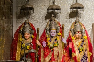 Tre statue di divinità indù vestite in abiti tradizionali
