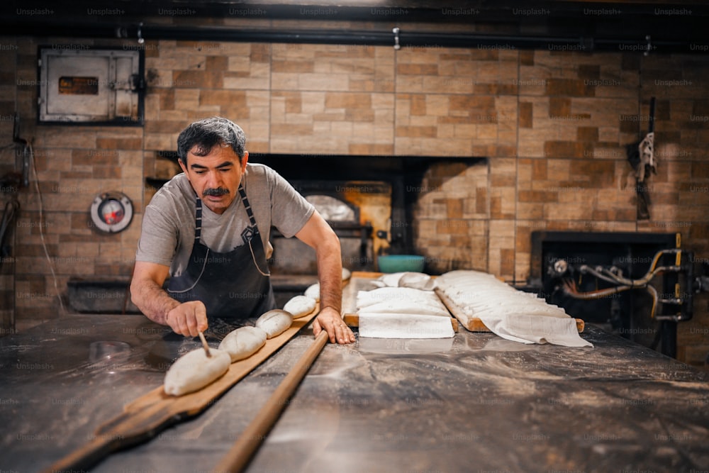 Un hombre está haciendo pan en una mesa