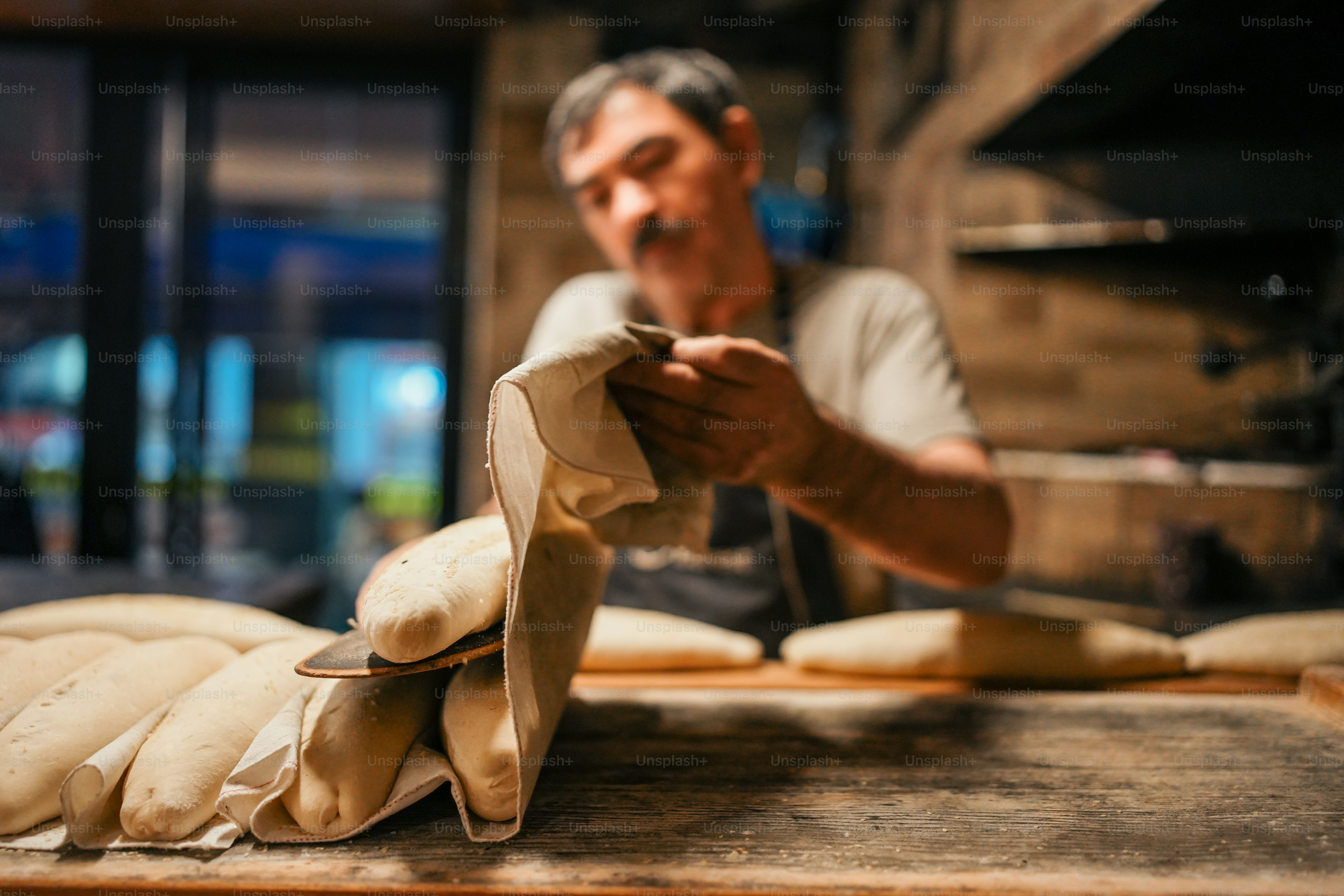Ein Mann backt Brot in einer Bäckerei