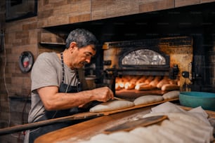 a man is making bread in an oven