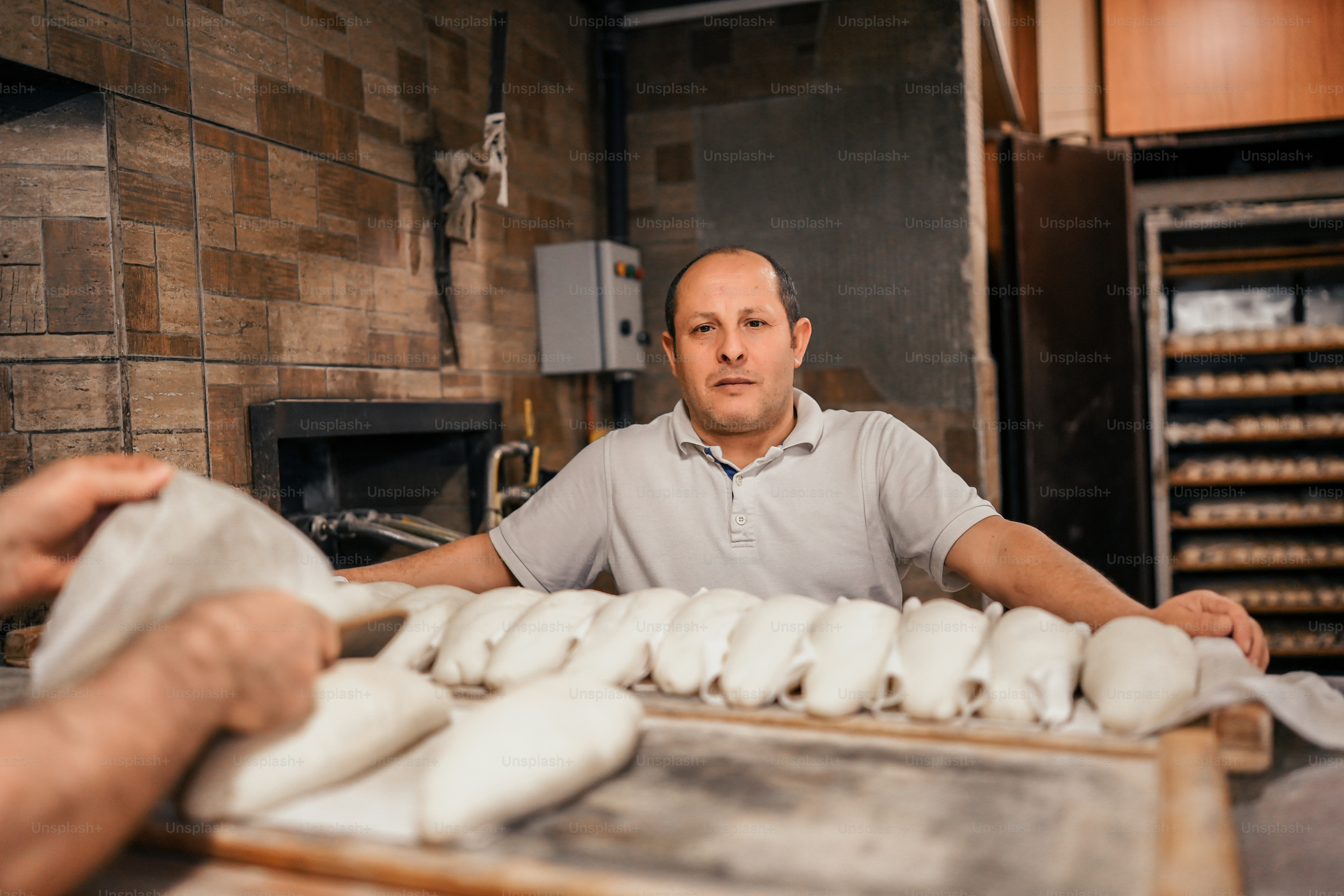 Ein Mann steht hinter einem Tresen voller Donuts