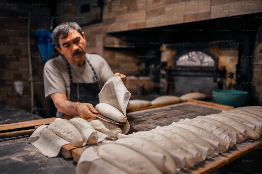 パン屋でパンを作っている男性